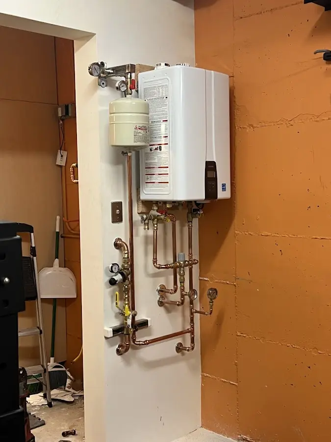 Plumbing technician inspecting water heater connections in Irving